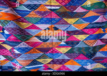 Vibrant geometric pattern with colorful triangles on a woven fabric surface. Ouarzazate, Morocco Stock Photo