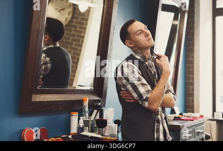 Bearded barber posing to camera at barbershop Stock Photo