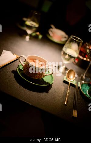 Elegant tea set with ornate cup and saucer on a dimly lit table. Shanghai, China Stock Photo
