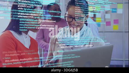Showing woman wearing glasses and scarf leading team with laptop in modern team room, code overlay Stock Photo