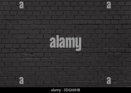 Even black brick wall with uniform masonry and slight signs of wear. The photo captures surface texture suitable for backgrounds or architectural visu Stock Photo