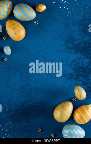Colorful blue and gold Easter eggs arranged on a blue textured background with small decorative elements. 3d rendering Stock Photo