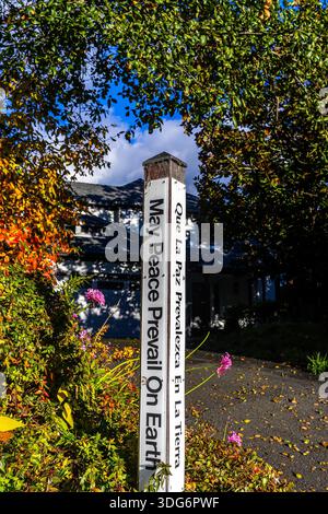 Peace Pole inscribed with the message "May Peace Prevail on Earth" in four languages, including English and Spanish Stock Photo