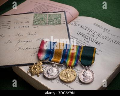 WW1 British military medals, comprising 1914-15 Star, British War Medal, a Victory Medal, Defence medal. Bereavement letter & Field Service Regs. Stock Photo