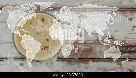 Sitting glass cup with saucer showing frothy crema on worn wooden table, map overlay, copy space Stock Photo