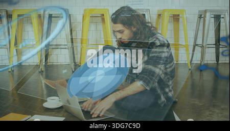 Typing man in plaid shirt and jeans, sitting on concrete at coworking with laptop, AR overlays Stock Photo