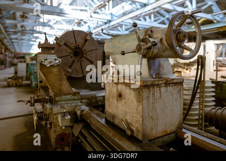 Vintage metalworking lathe with teal paint and manual control handles. Traditional manufacturing equipment for engineering and metal parts production Stock Photo