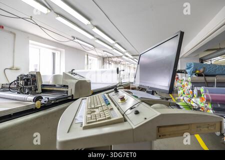 Automated CNC fabric cutting machine with control panel. High tech industrial equipment for high precision textile rozkriy in professional garment man Stock Photo