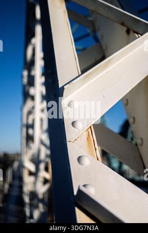 Close up on the white metal structure of the 1933 iron bridge located in San Juan de Aznalfarache, Seville, Spain. Structural detail and riveted conne Stock Photo