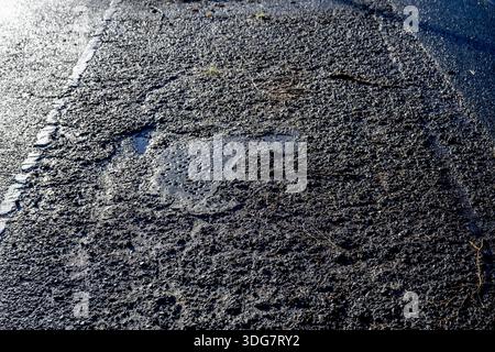 ROTTERDAM - Due to the severe frost and cold and the road salt, the asphalt has been damaged and broken. Road surface is damaged by frost because water seeps into small cracks in the asphalt, freezes, expands and thus damages the road surface, leading to loose stones, larger cracks and holes, especially after periods of frost with heavy rainfall and thaw. ROBIN UTRECHT /ANP netherlands out - belgium out Stock Photo