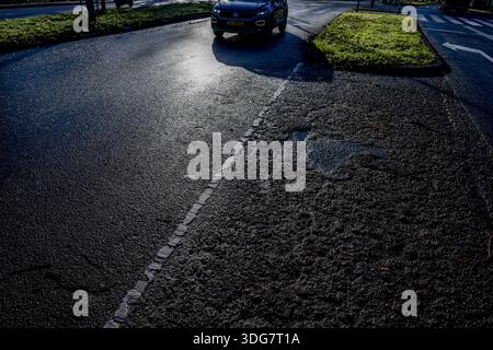 ROTTERDAM - Due to the severe frost and cold and the road salt, the asphalt has been damaged and broken. Road surface is damaged by frost because water seeps into small cracks in the asphalt, freezes, expands and thus damages the road surface, leading to loose stones, larger cracks and holes, especially after periods of frost with heavy rainfall and thaw. ROBIN UTRECHT /ANP netherlands out - belgium out Stock Photo