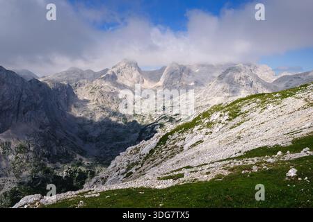 Stunning, misty view of Triglav mountain range with sharp mountain ridges under a cloudy sky Stock Photo