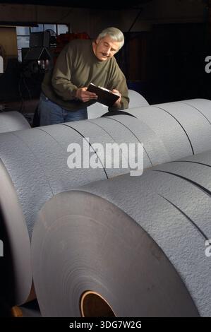 Paper mill working inspecting final product, New Jersey USA Stock Photo