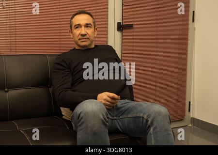 Man relaxing on a sofa, holding a remote control while watching television Stock Photo