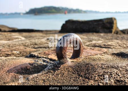 rusty steel ring embedded in the paving stones on the seafront for mooring boats Stock Photo