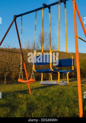 Close-up of a playground swing with colorful seats on a clear day, highlighting playful details and outdoor joy. Stock Photo
