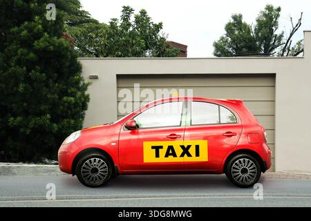 Red taxi car with label and top sign waiting near house Stock Photo
