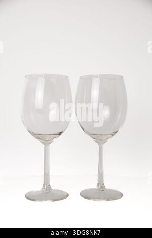 Two empty wine glasses in a minimalist studio setup, isolated on a white background with copy space, suitable for hospitality and celebration design. Stock Photo
