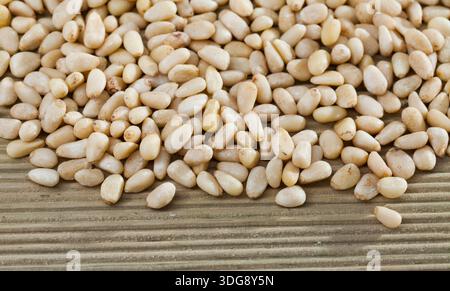 Pine nuts scattered on wooden surface Stock Photo