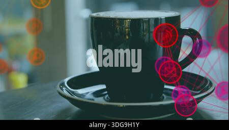 Displaying black ceramic cup and saucer sitting on cafe table, showing frothy coffee and red nodes Stock Photo