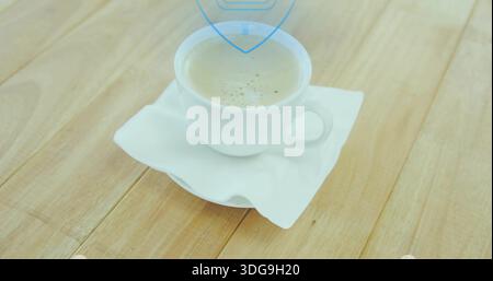 Sitting white ceramic cup holding light-brown coffee with thin crema on napkin at kitchen table Stock Photo