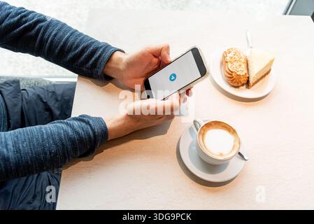 Bar, Montenegro, 9 January 2026, Man calls or writes message through modern Telegram mobile messenger while sitting in cafe Stock Photo