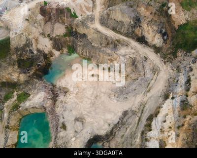 Aerial view of the dramatic quarry's rugged landscape, where turquoise pools meet weathered rocks in a symphony of textures and tones, Foz do Arelho, Stock Photo