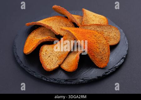 Rye bread crackers in spices on dark background, Beer snack, Stock Photo