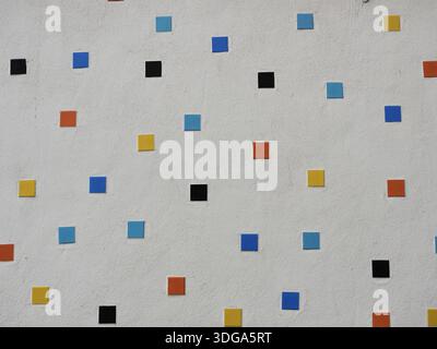 Modern facade with colorful mosaic of square tiles on light plaster. Suitable for background and text areas. Copyspace. Stock Photo