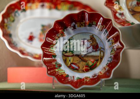 Close-up of a festive ceramic Christmas plate featuring a vintage-style illustration with traditional toys and ornaments. Stock Photo