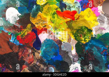 Close-up of thick multicolored paint. Textured strokes of blue, yellow, red, and green create a dynamic abstract texture. Concept of modern art Stock Photo