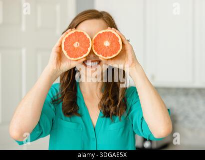 Beautiful Woman Holding Ruby Red Grapefruit Cut in Half Stock Photo