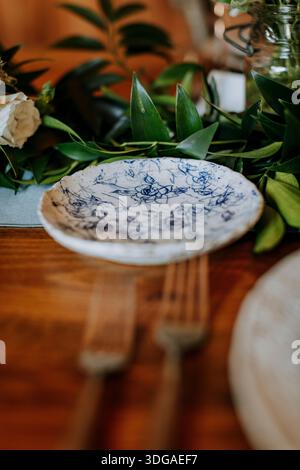 homemade pottery plate on table with flowers and leaves Stock Photo