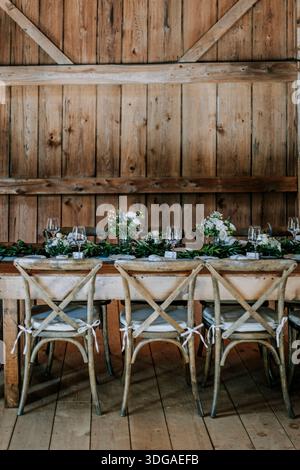 Formal table setting with flowers in a rustic barn, rehearsal dinner Stock Photo