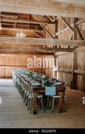 Formal table setting for rehearsal dinner in rustic barn setting Stock Photo
