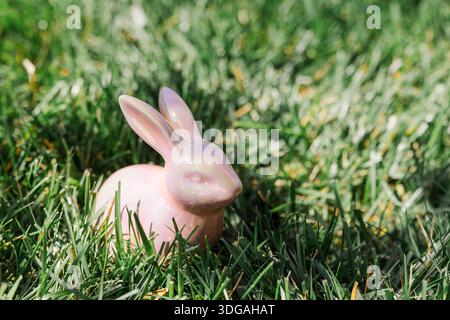 Pink ceramic Easter bunny in the grass. Stock Photo