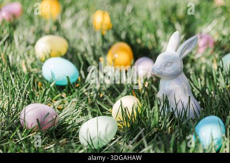 Easter eggs and ceramic Easter bunny in green grass. Stock Photo