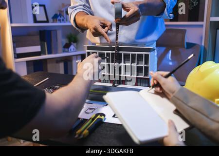 A group of engineers and architects collaborate on a construction project, discussing ideas and sharing technical plans to design innovative modern bu Stock Photo