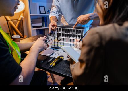 Engineers and architects analyze construction models and discuss project strategies, combining technical knowledge and creative ideas to achieve succe Stock Photo