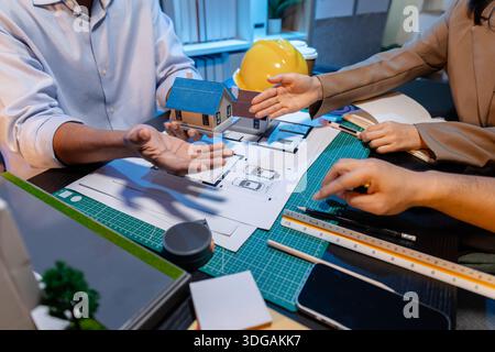 Engineers and architects analyze construction models and discuss project strategies, combining technical knowledge and creative ideas to achieve succe Stock Photo