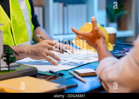 A team of architects and engineers coordinates on an architectural project, reviewing design concepts and technical plans to ensure efficiency and cre Stock Photo