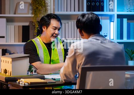 A team of architects and engineers coordinates on an architectural project, reviewing design concepts and technical plans to ensure efficiency and cre Stock Photo