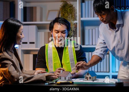 A team of architects and engineers coordinates on an architectural project, reviewing design concepts and technical plans to ensure efficiency and cre Stock Photo
