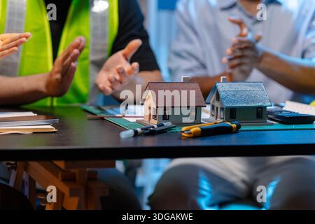 A team of architects and engineers coordinates on an architectural project, reviewing design concepts and technical plans to ensure efficiency and cre Stock Photo