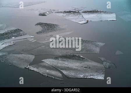 Broken Ice Sheets Floating on Calm Water Surface in Winter Stock Photo