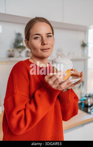 Woman cake kitchen bright modern holding traditional easter kulich dessert Stock Photo