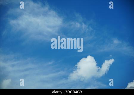 A bright blue sky with wispy white clouds Stock Photo