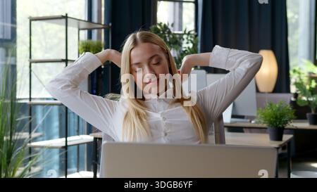 Caucasian business woman working with laptop resting tired feeling at table businesswoman relaxing stretching after typing computer work project Stock Photo