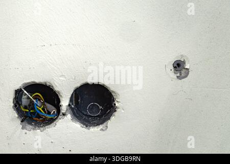 Openings in the wall with electrical boxes, replacing the electrical installation, removing electrical sockets from the wall Stock Photo