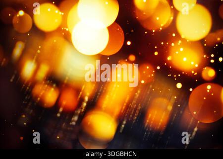 Golden bokeh lights create a mesmerizing backdrop with shimmering effects, ideal for enhancing designs, celebrations, and artistic projects, evoking warmth and joy Stock Photo